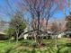 Landscaped front yard with flowering trees and vibrant spring flowers at 8728 Holliday Dr, Indianapolis, IN 46260