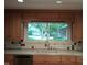 Kitchen featuring wood cabinets, a large window over the sink and tiled countertops at 8728 Holliday Dr, Indianapolis, IN 46260