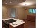 Open kitchen view with island cooktop, light fixture and cabinetry, and adjoining dining area at 8728 Holliday Dr, Indianapolis, IN 46260