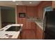 Traditional kitchen featuring wood cabinets, island with cooktop, and neutral tile backsplash at 8728 Holliday Dr, Indianapolis, IN 46260