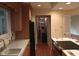 Bright kitchen showcasing wood cabinets, black appliances, sink, and an entryway into the utility area at 8728 Holliday Dr, Indianapolis, IN 46260