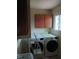 Laundry room with modern washer and dryer units and wall-mounted cabinets at 8728 Holliday Dr, Indianapolis, IN 46260