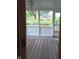 Screened sunroom with tile floor and views of a backyard shed and greenery at 8728 Holliday Dr, Indianapolis, IN 46260