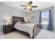 Comfortable bedroom with a ceiling fan, a window, and dark furniture at 9422 Oakley Dr, Indianapolis, IN 46260