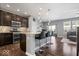 Open kitchen with granite island, pendant lights, stainless steel appliances, and hardwood floors, leading to living area at 9422 Oakley Dr, Indianapolis, IN 46260