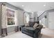 A charming living room features a comfy loveseat, windows, and a staircase at 9422 Oakley Dr, Indianapolis, IN 46260