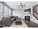 Bright living room with a ceiling fan, fireplace, large windows, and a comfortable gray sectional sofa at 9422 Oakley Dr, Indianapolis, IN 46260