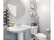 Stylish powder room with pedestal sink, decorative mirror, and tasteful accents at 9422 Oakley Dr, Indianapolis, IN 46260