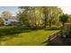 Expansive backyard featuring a lush lawn, mature trees, and a wooden deck perfect for outdoor entertaining at 950 Hearthside Dr, Brownsburg, IN 46112
