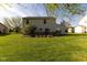 Spacious backyard with a deck, a lush green lawn, and mature trees at 950 Hearthside Dr, Brownsburg, IN 46112