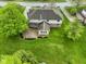 Aerial view of the backyard featuring a brick patio and large lawn, landscaping, and mature trees at 960 Arrowwood Dr, Carmel, IN 46033