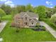 Stunning aerial view of a well-kept brick home with a large yard, mature trees, and basketball court at 960 Arrowwood Dr, Carmel, IN 46033