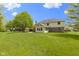 Large backyard featuring a spacious lawn, brick patio, and a sunroom addition to the home at 960 Arrowwood Dr, Carmel, IN 46033