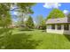 Landscaped backyard featuring a sunroom addition, mature trees and a lush lawn at 960 Arrowwood Dr, Carmel, IN 46033