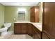 Bathroom with a toilet, vanity, drawers, mirror, and a counter top with two sinks, plus green walls at 960 Arrowwood Dr, Carmel, IN 46033