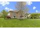 Charming brick two-story home with manicured lawn and blooming tree in the front at 960 Arrowwood Dr, Carmel, IN 46033