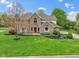 Beautifully landscaped two-story brick home with a basketball court, mature trees, and lush lawn at 960 Arrowwood Dr, Carmel, IN 46033