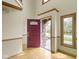 Bright foyer with hardwood floors, a red front door, and natural light streaming through the windows at 960 Arrowwood Dr, Carmel, IN 46033