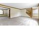 Spacious living room with neutral carpet, wooden trim, and stairway at 960 Arrowwood Dr, Carmel, IN 46033