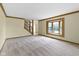 Carpeted living room featuring a large bay window and stairway access at 960 Arrowwood Dr, Carmel, IN 46033