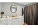 Bathroom featuring double vanity, oval mirror and tub with black shower curtain at 1121 Eugene St, Indianapolis, IN 46208
