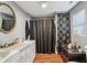 Bathroom featuring double vanity, oval mirror, and decorative shower curtain at 1121 Eugene St, Indianapolis, IN 46208