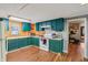 Bright kitchen featuring teal cabinets and white appliances at 1121 Eugene St, Indianapolis, IN 46208