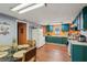 Eat-in kitchen featuring bold teal cabinets and an island with a glass-top table at 1121 Eugene St, Indianapolis, IN 46208