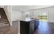 Spacious kitchen featuring an island with a sink, dark cabinets, and a view of the backyard at 113 Hunter'S Rdg Dr, Danville, IN 46122