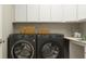 Laundry room with washer and dryer, white cabinets, and modern decor at 11641 Aubrey Ln, Fishers, IN 46040