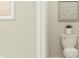 A clean, half bathroom featuring a standard toilet with modern wall decor and neutral color palette at 11682 Aubrey Ln, Fishers, IN 46040