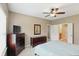Cozy bedroom with light-colored walls, ceiling fan, and connecting bathroom at 11716 Whisper Cove Dr, Fishers, IN 46037