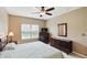 Well-lit bedroom with a ceiling fan, dresser, and window view at 11716 Whisper Cove Dr, Fishers, IN 46037