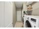 Bright laundry room with modern washer and dryer and wire shelving, offering ample storage space at 11716 Whisper Cove Dr, Fishers, IN 46037