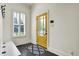 Bright foyer features a yellow front door, dark wood floors, stylish rug, and a window with plantation shutters at 12605 Branford St, Carmel, IN 46032
