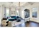 Bright living room featuring a blue velvet sofa, hardwood floors, modern lighting, and large windows at 12605 Branford St, Carmel, IN 46032