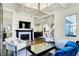 Open-concept living room with a fireplace, hardwood floors, and views into the kitchen, creating an inviting space at 12605 Branford St, Carmel, IN 46032