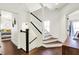Bright, modern staircase features hardwood flooring, black handrails, and ample natural light at 12605 Branford St, Carmel, IN 46032