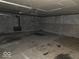 The unfinished basement features a cement floor, brick walls, and pipes at 1354 Roache St, Indianapolis, IN 46208