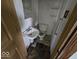 This outdated bathroom includes a toilet, sink, mirror and shelving at 1354 Roache St, Indianapolis, IN 46208