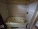 An outdated bathroom features a large tub and tile backsplash at 1354 Roache St, Indianapolis, IN 46208