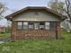 Charming home featuring a brick facade and a symmetrical design, set against a backdrop of green grass at 1354 Roache St, Indianapolis, IN 46208