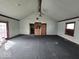 The outdated living room has a vaulted ceiling, a ceiling fan, and sliding glass doors at 1354 Roache St, Indianapolis, IN 46208