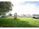 Spacious backyard featuring a wooden playset, green lawn, and a privacy fence at 14153 Jasmine Ct, Fishers, IN 46038