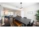 Cozy dining room with modern lighting, a black table with bench seating, and an open layout to the living area at 14153 Jasmine Ct, Fishers, IN 46038