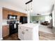 Open concept kitchen features wood cabinets, a center island, and sightlines into the living room at 14153 Jasmine Ct, Fishers, IN 46038