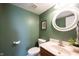 Stylish powder room with a decorative mirror, modern fixtures, and green accents at 14153 Jasmine Ct, Fishers, IN 46038