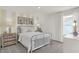 Bright bedroom with a metal bed frame, neutral walls and decor, and a large sunny window at 15400 Manderley St, Fishers, IN 46040