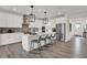 Bright kitchen boasts white cabinets, stainless appliances, kitchen island with seating and modern pendant lighting at 15400 Manderley St, Fishers, IN 46040