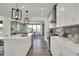 Well-lit kitchen featuring white cabinetry, stainless steel appliances and gray backsplash, with an open view to the living area at 15400 Manderley St, Fishers, IN 46040